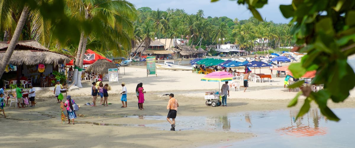 Puerto Escondido mostrando escenas tropicales, un hotel o resort de lujo y una playa de arena