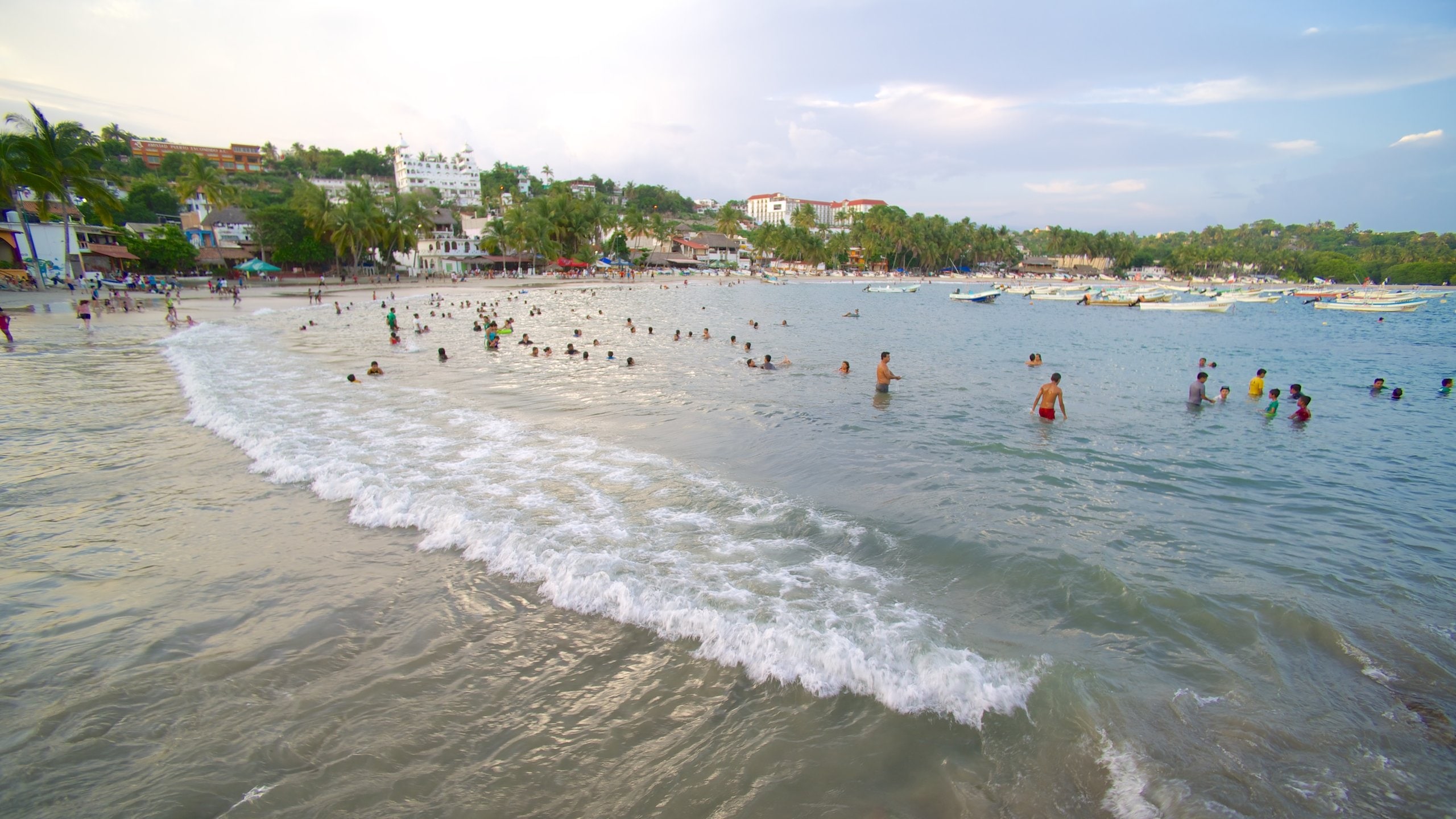 Puerto Escondido que incluye olas, una ciudad costera y paseos en lancha