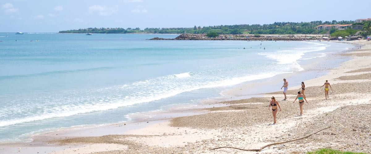 Punta Mita showing a sandy beach and landscape views as well as a small group of people
