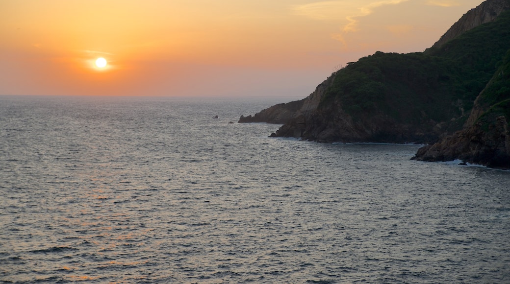 Sinfonía mostrando um pôr do sol, paisagem e litoral rochoso