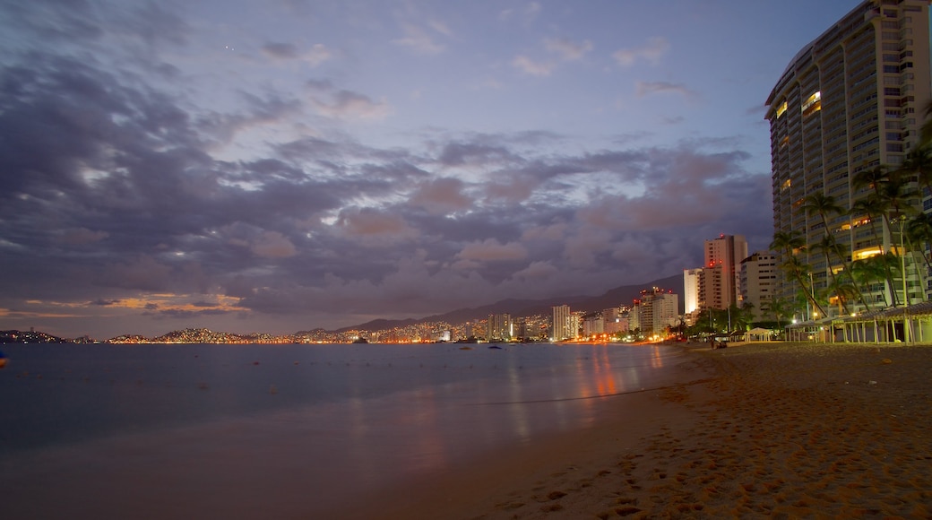 Icacos Beach showing night scenes, a beach and a coastal town