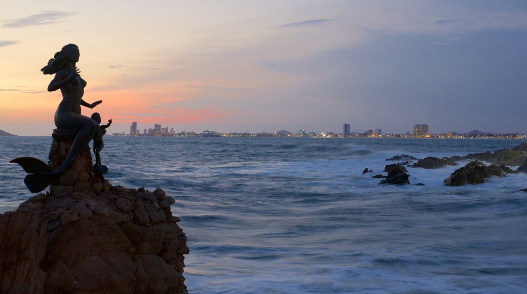 Punta de clavadistas que incluye una puesta de sol, costa rocosa y horizonte