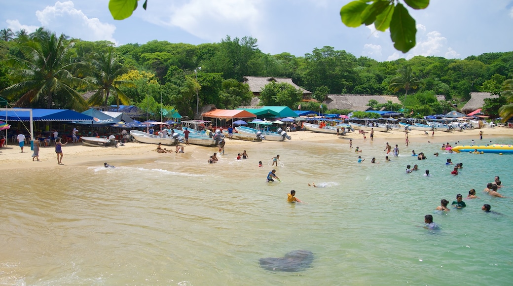 Playa Puerto Angelito que incluye una playa de arena, natación y escenas tropicales