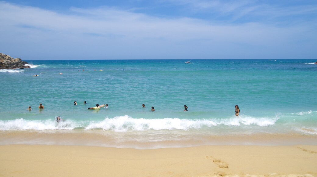 Carrizalillo Beach which includes swimming and a sandy beach as well as a large group of people