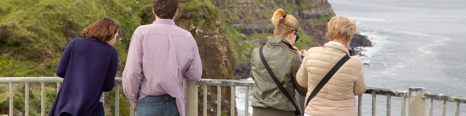 Kilt Rock featuring rocky coastline and views as well as a family
