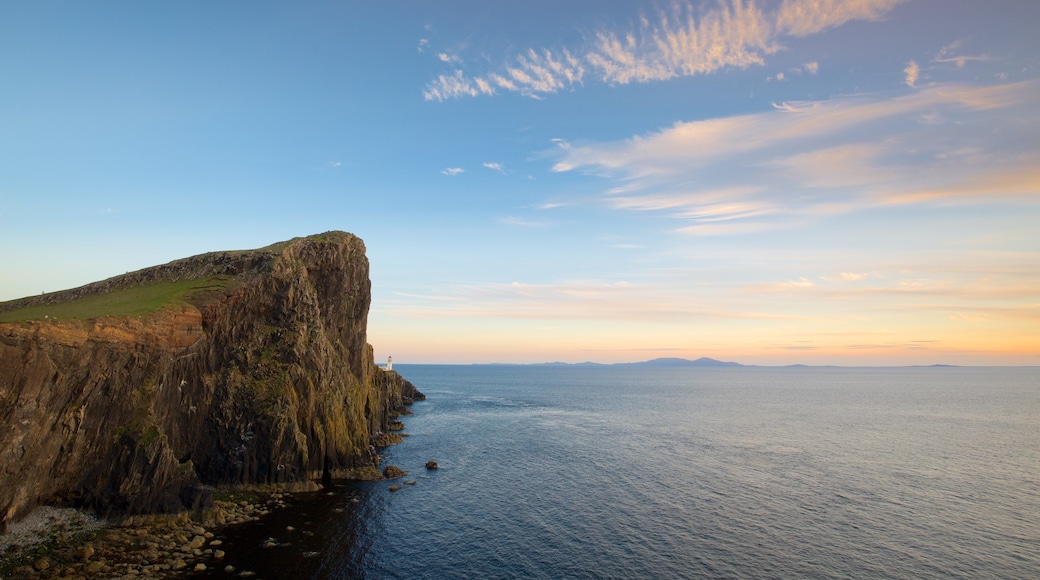 Isle of Skye ofreciendo costa rocosa, montañas y un faro