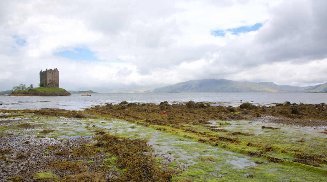 Castle Stalker featuring a castle, heritage elements and a lake or waterhole