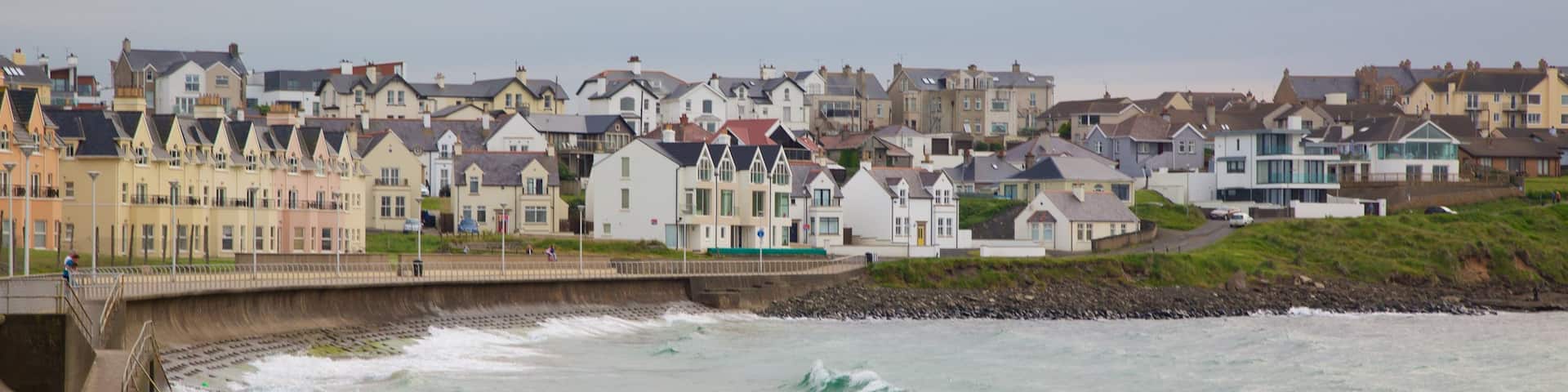 Portrush Beach which includes a sandy beach, a coastal town and general coastal views
