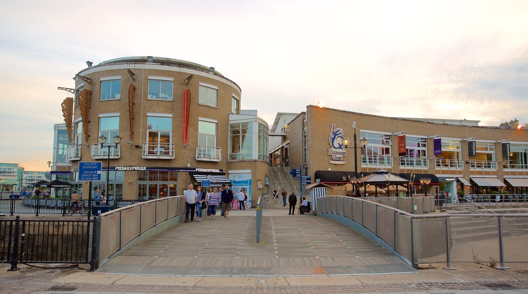 Mermaid Quay featuring a bridge as well as a small group of people