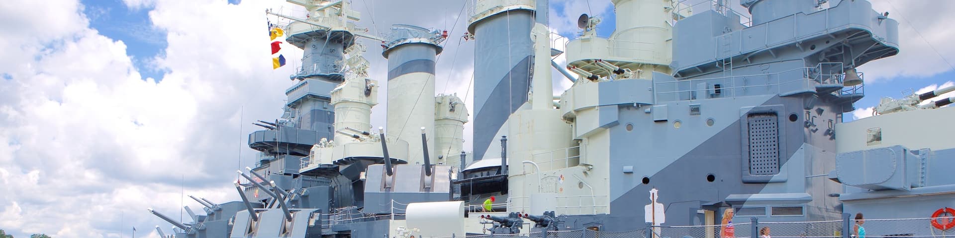 Battleship North Carolina featuring heritage elements as well as a small group of people