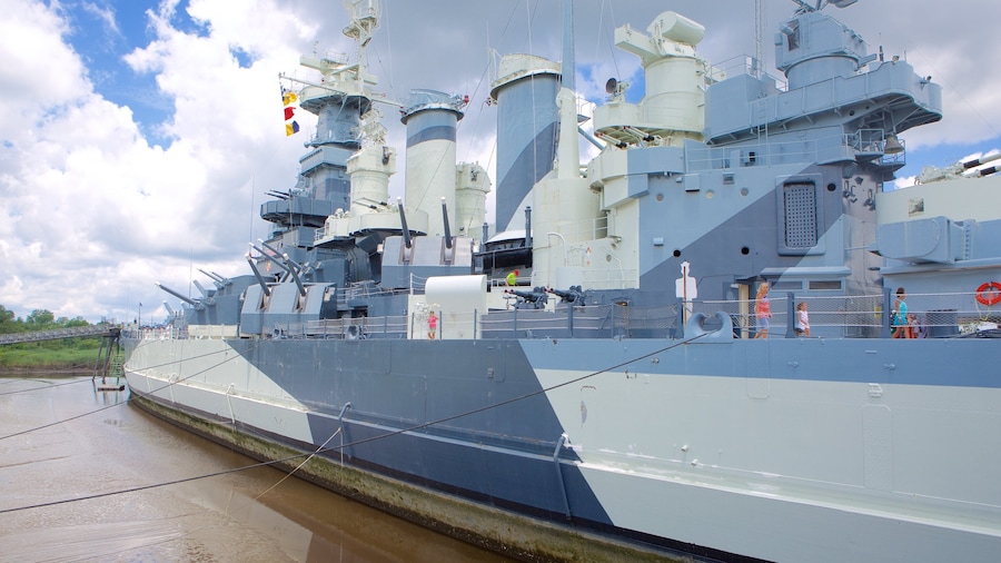 Battleship Carolina del Norte mostrando elementos del patrimonio y también un pequeño grupo de personas