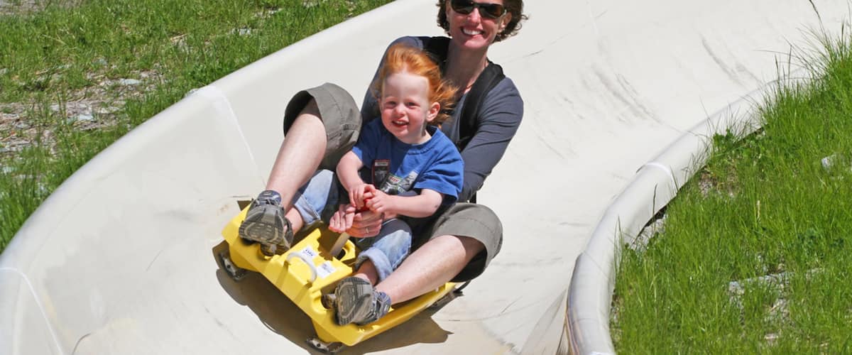 Whitefish Mountain Ski Resort showing snow tubing as well as a family