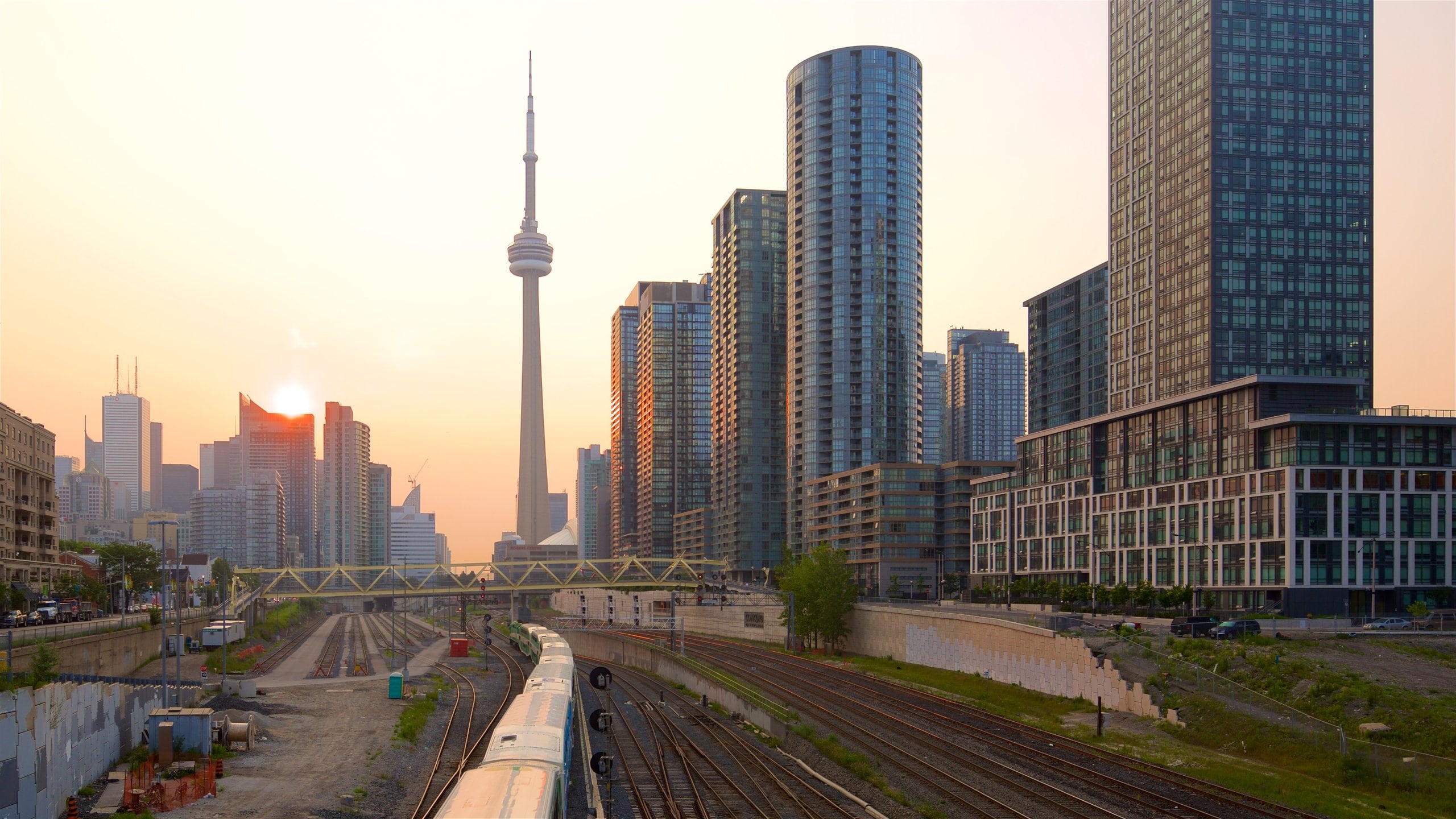 Toronto ofreciendo una puesta de sol, un rascacielos y artículos de ferrocarril