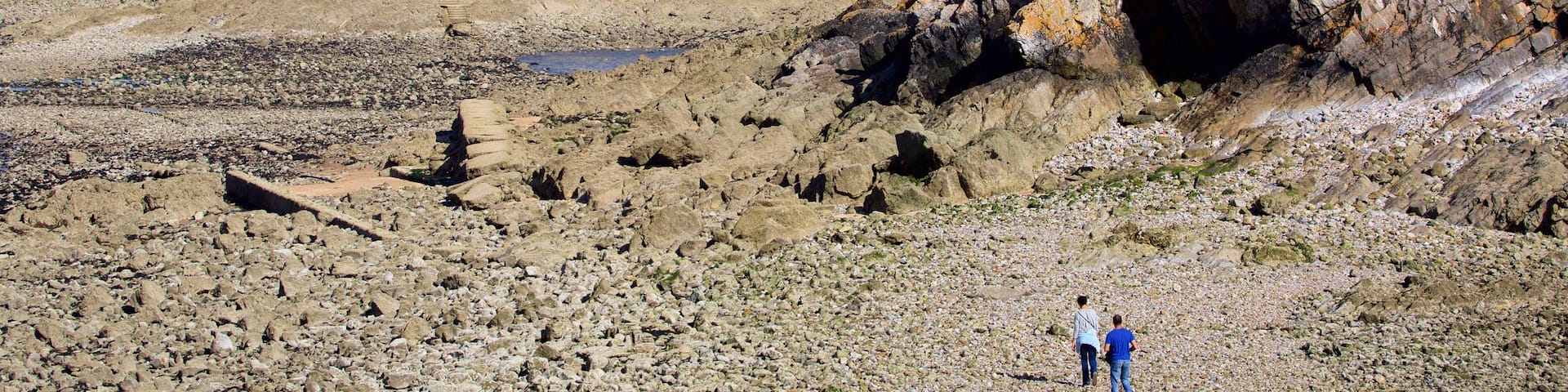 Mumbles Lighthouse which includes mountains, a lighthouse and a pebble beach