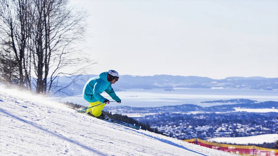Parque invernal de Oslo ofreciendo ski en la nieve y nieve y también un hombre