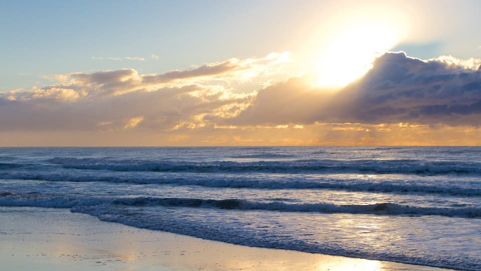 Surfers Paradise que incluye una playa de arena y una puesta de sol