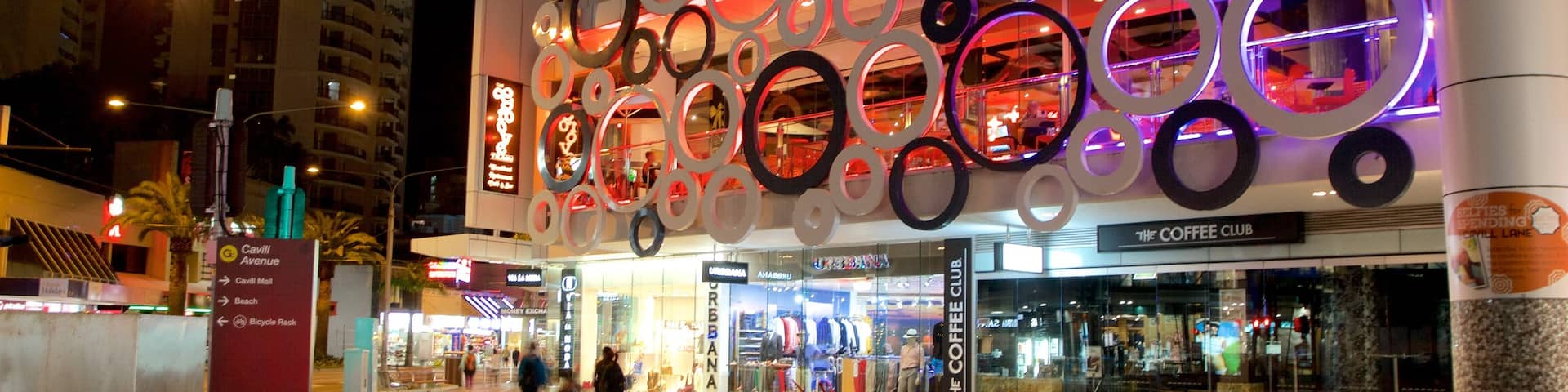 Cavill Avenue que incluye escenas nocturnas, compras y una ciudad
