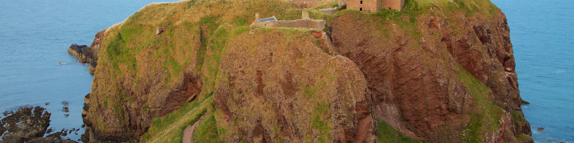 Dunnottar Castle showing general coastal views, farmland and heritage elements
