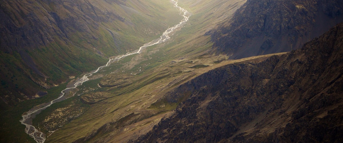 Chugach State Park showing a gorge or canyon, a river or creek and mountains