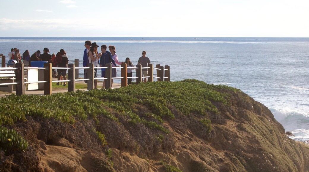 La Jolla Cove which includes rocky coastline and general coastal views as well as a small group of people