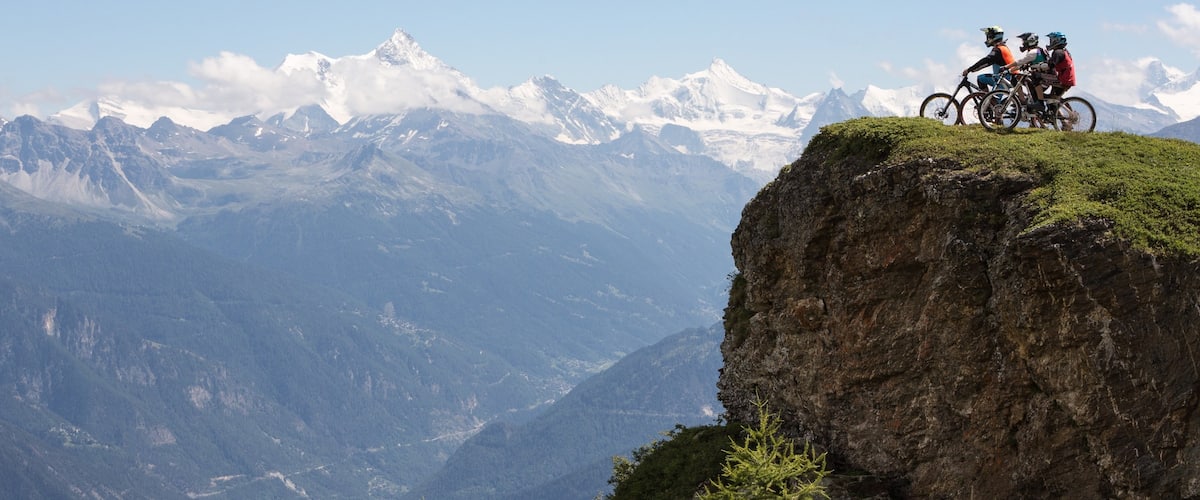 Crans-Montana Ski Resort mostrando montanhas e mountain bike assim como um pequeno grupo de pessoas