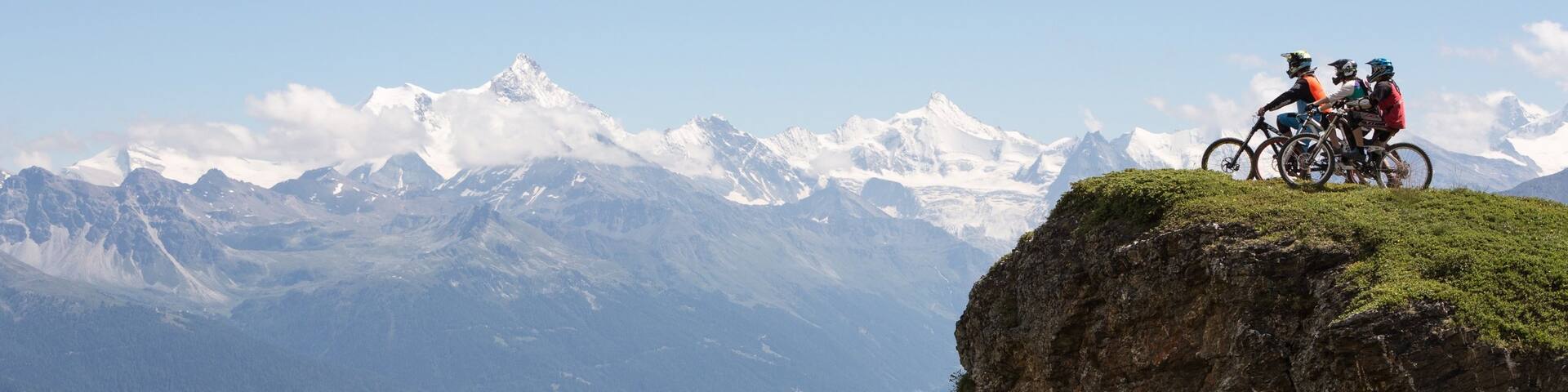 Crans-Montana Ski Resort showing mountains and mountain biking as well as a small group of people