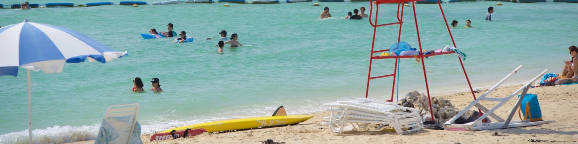 Okinawa showing a beach and swimming as well as a large group of people