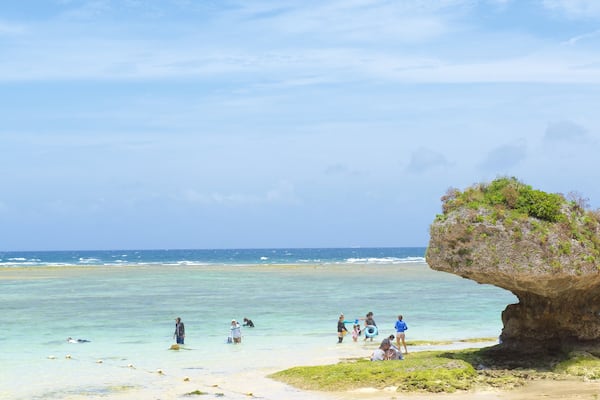 Plage Nirai mettant en vedette plage de sable aussi bien que important groupe de personnes