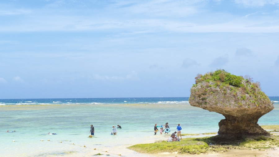 Nirai Beach showing a beach as well as a large group of people