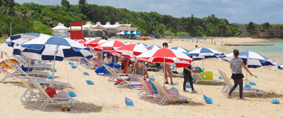 Nirai Beach showing a sandy beach as well as a large group of people
