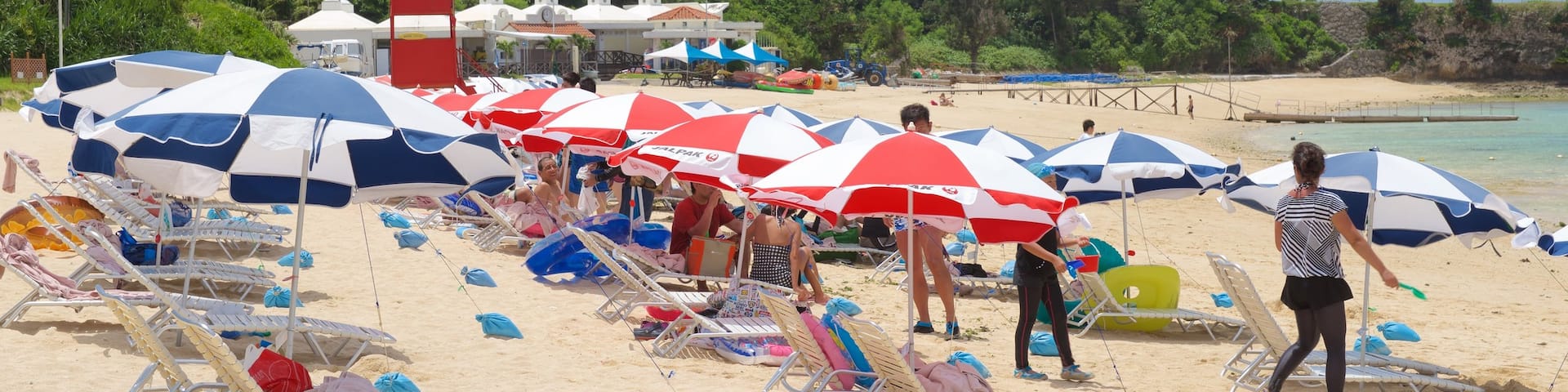 Nirai Beach showing a sandy beach as well as a large group of people