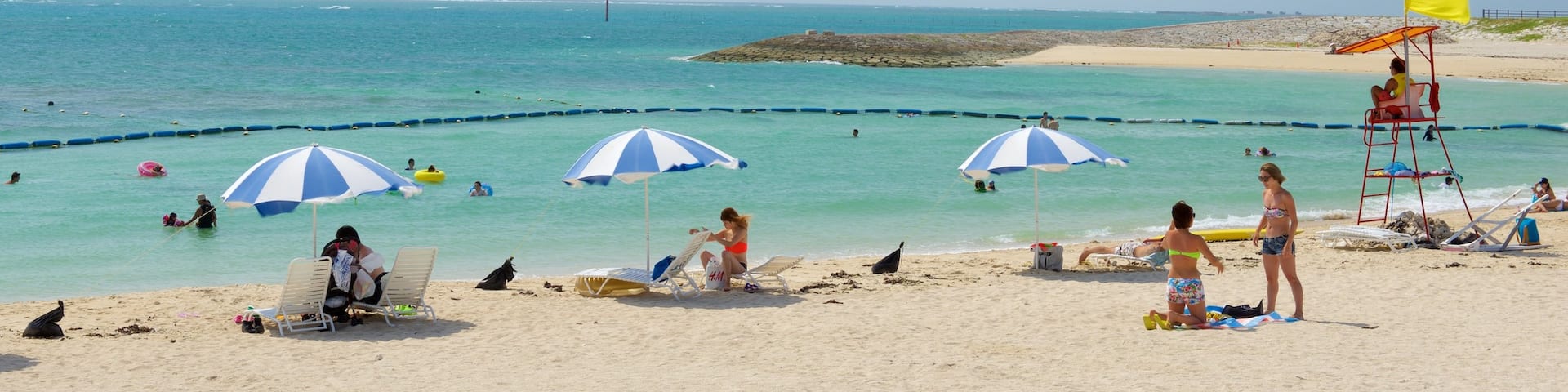 Okinawa which includes swimming and a beach as well as a large group of people