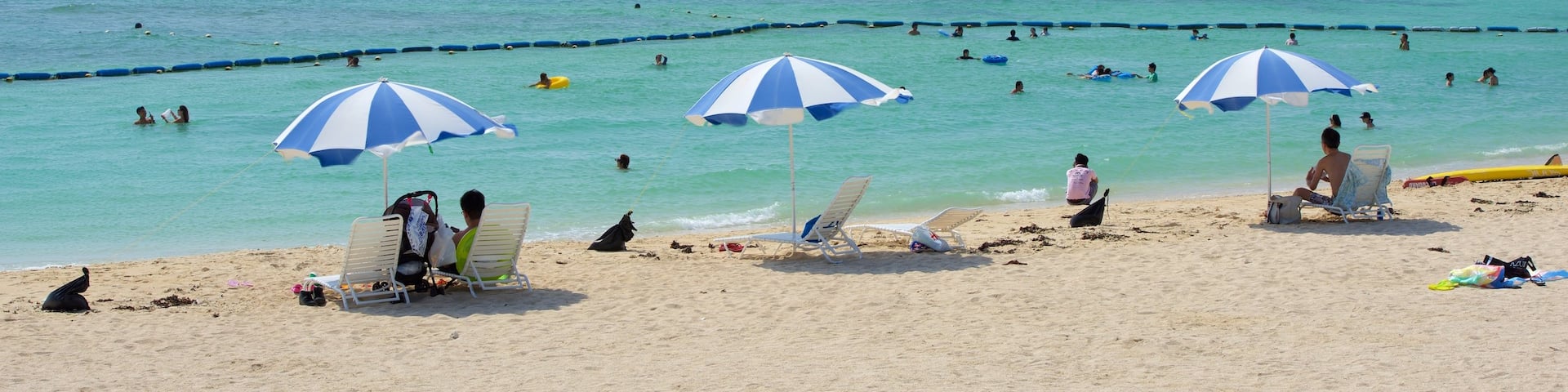 Okinawa som inkluderar bad och en strand sÄvÀl som en stor grupp av mÀnniskor
