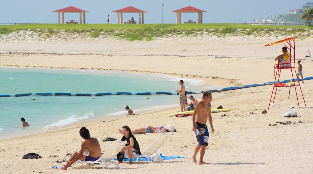 Okinawa which includes a sandy beach and swimming as well as a large group of people