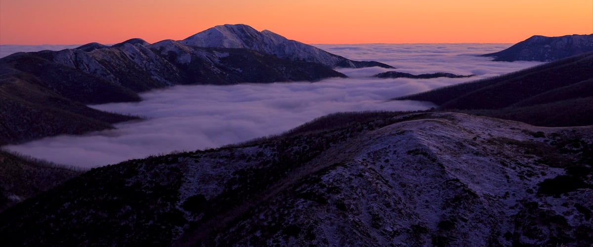 Cumbres de Hotham mostrando nieve, una puesta de sol y montañas