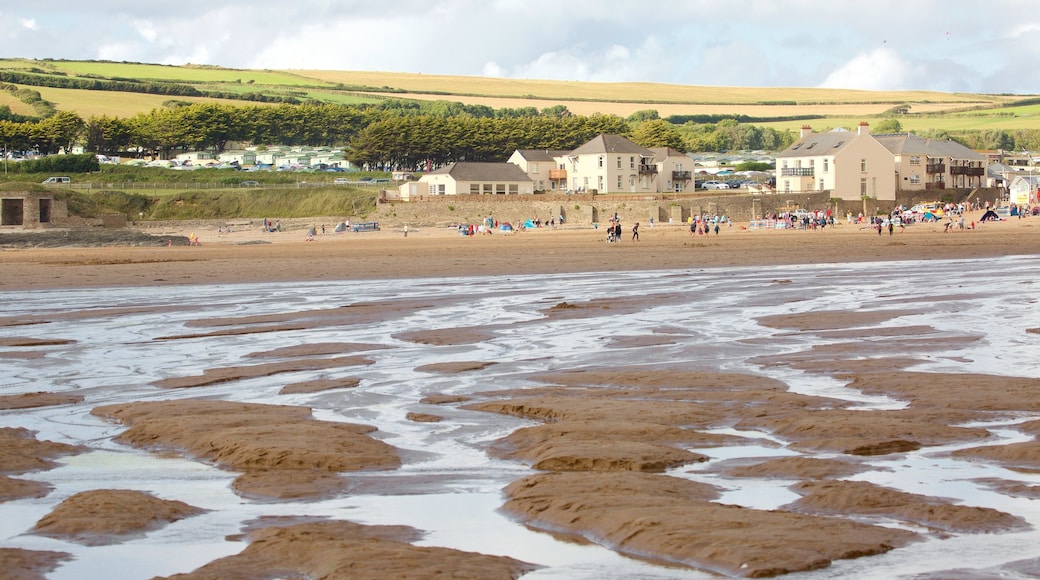 Croyde which includes a coastal town and a beach as well as a large group of people