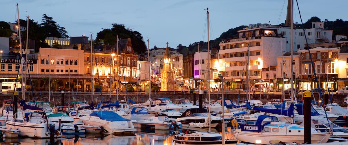 Torquay ofreciendo una ciudad costera, una marina y escenas nocturnas