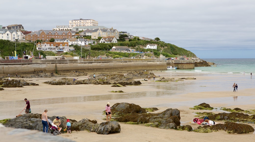 Newquay featuring a beach and a coastal town as well as a large group of people