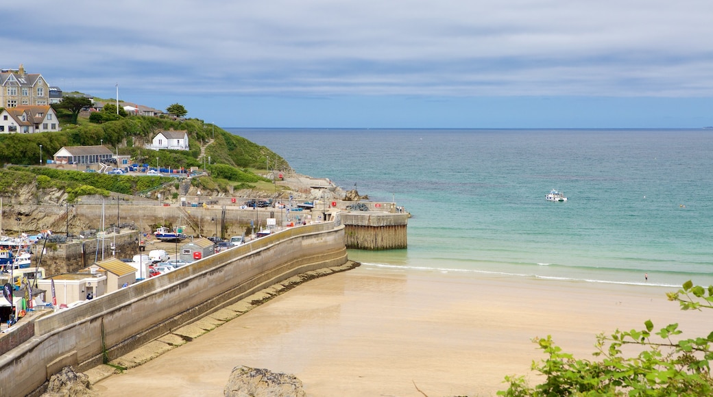 Newquay som visar en kuststad och en sandstrand