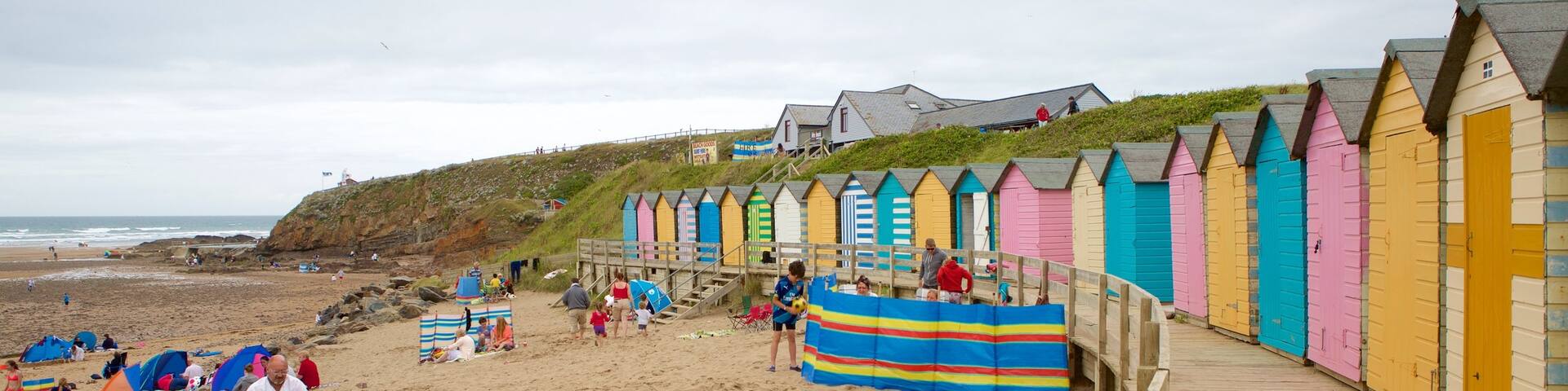 Bude Beach showing a coastal town and a sandy beach as well as a large group of people