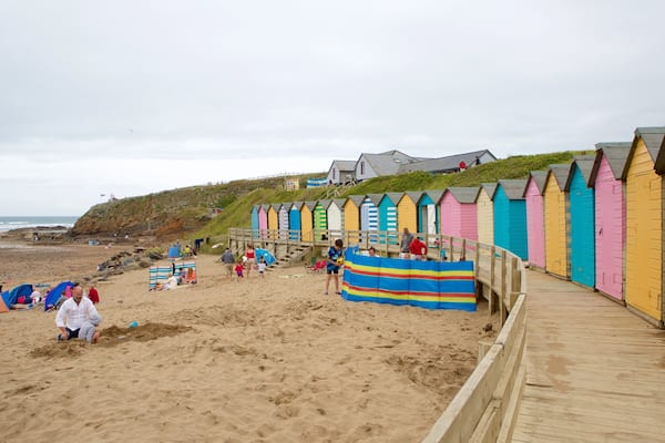 Bude Beach showing a coastal town and a sandy beach as well as a large group of people