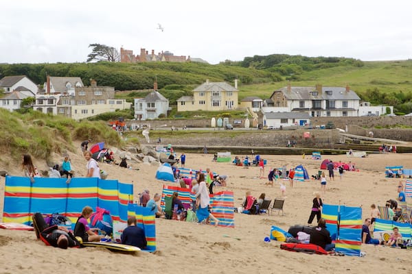 Bude Beach featuring a coastal town and a sandy beach as well as a large group of people