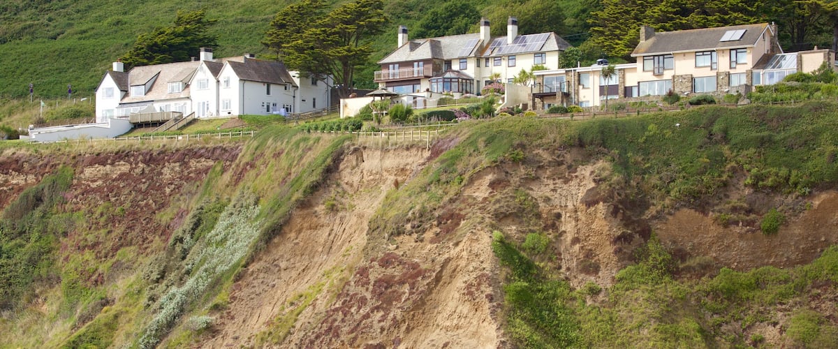 Saunton which includes a coastal town and rocky coastline