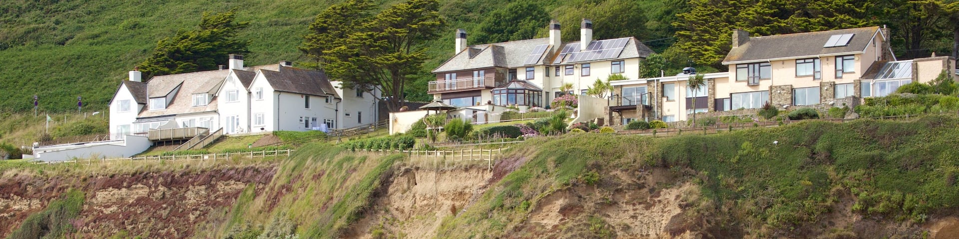 Saunton which includes a coastal town and rocky coastline