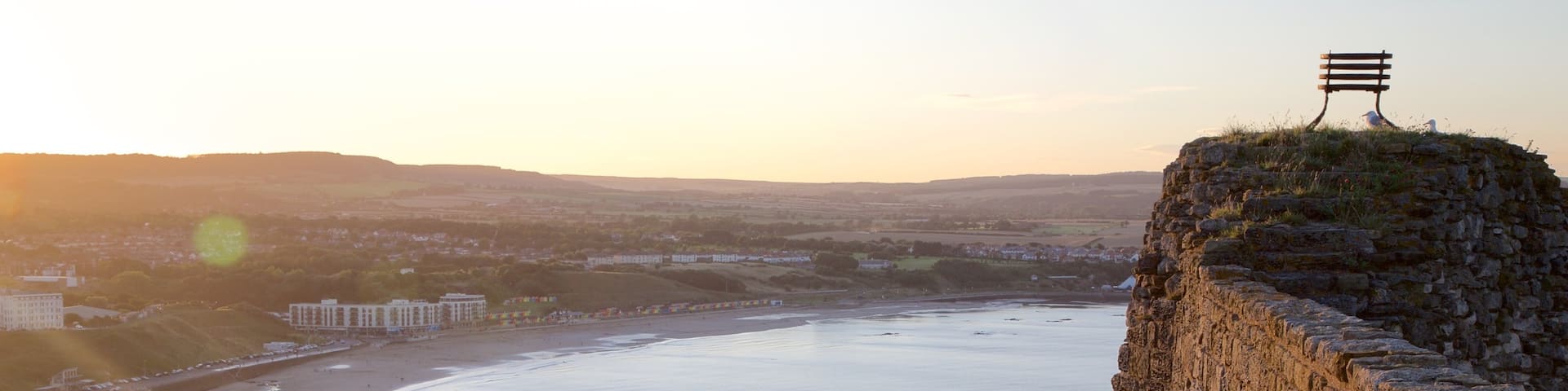 Scarborough Castle which includes views, a sandy beach and a sunset