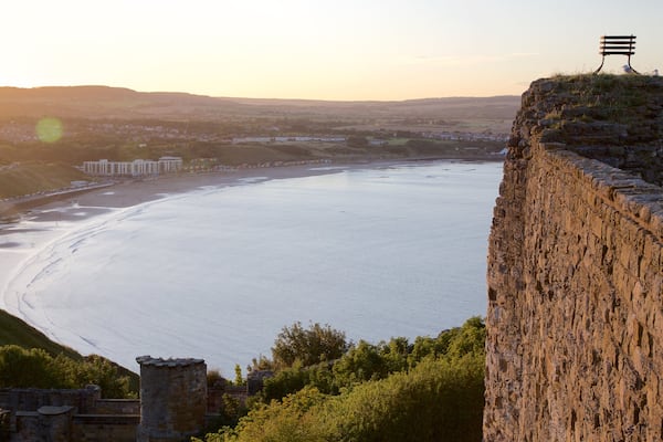 Castello di Scarborough che include oggetti d\'epoca, spiaggia e tramonto