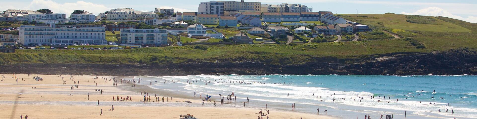 Fistral Beach which includes a coastal town, rugged coastline and a sandy beach
