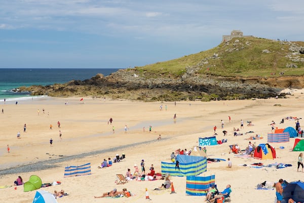 Plage de Porthmeor qui includes plage et ville côtière aussi bien que important groupe de personnes