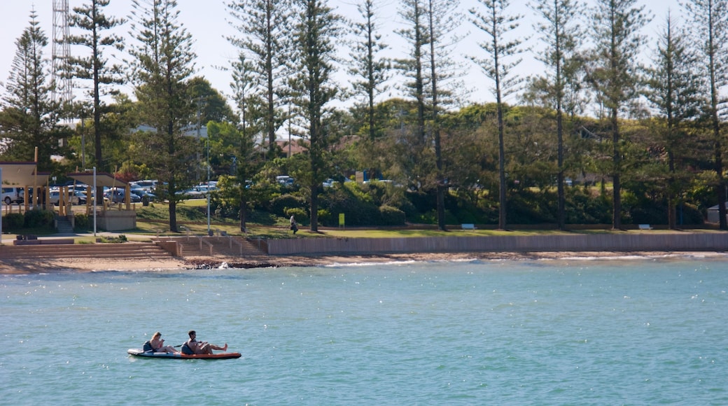 Redcliffe caratteristiche di spiaggia e kayak o canoa cosi come un piccolo gruppo di persone