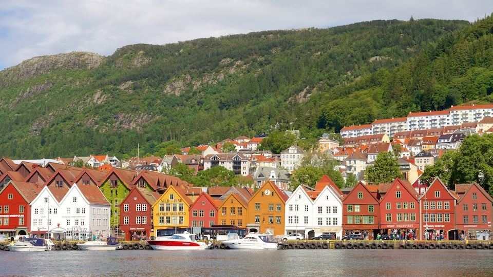 Bryggen som omfatter en lille by eller en landsby, klippekystlinje og bådsejlads